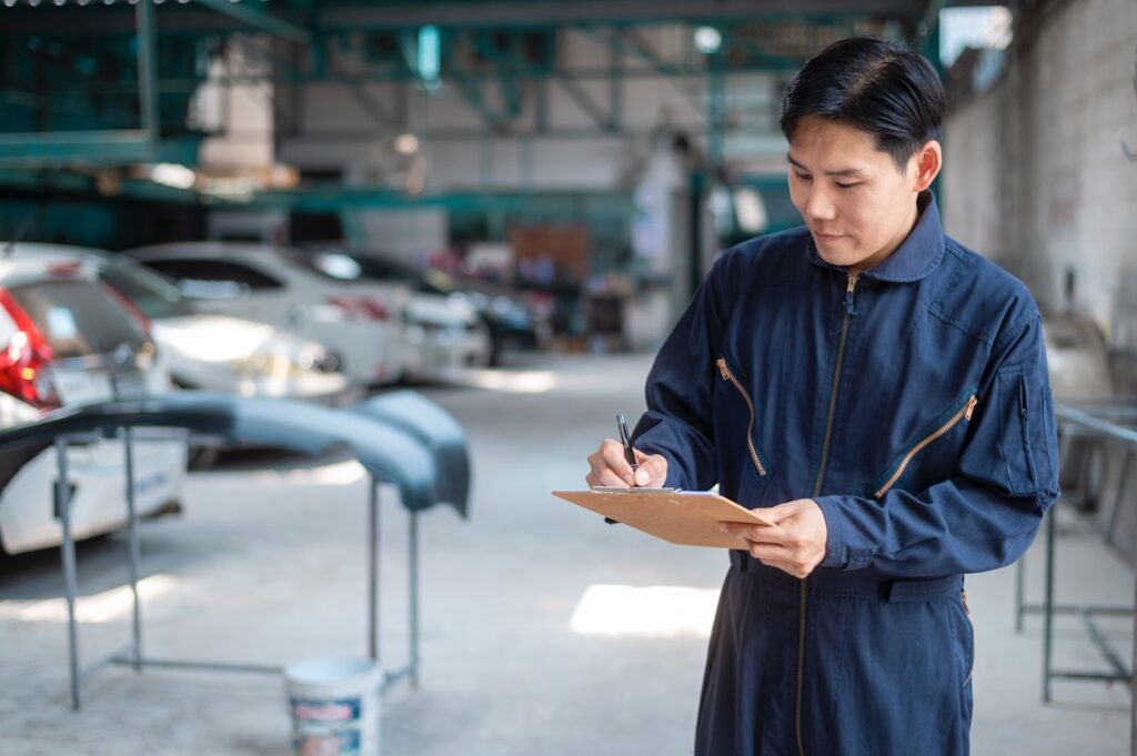 A car mechanic writing on his board