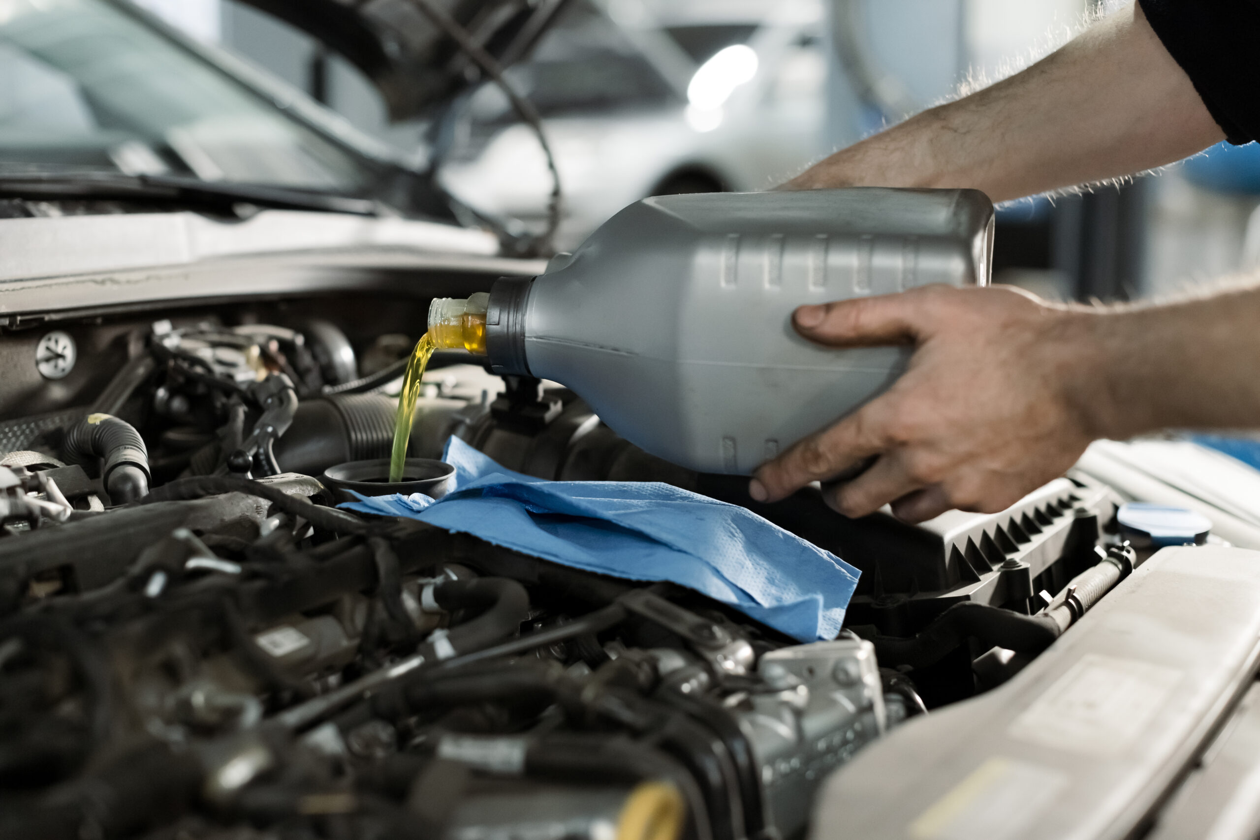 Mechanic Adding Oil to Car Engine During Service