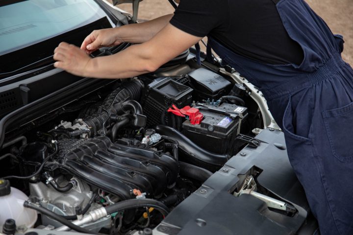 Mechanic opening car bonnet to fix wiper blades
